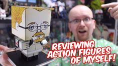 a man holding up a paper toy with an image of a cartoon character on it and the words reviewing action figures of myself