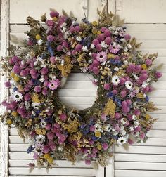 a wreath made out of dried flowers on a door