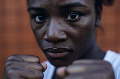 a close up of a person wearing a white shirt and pointing to the camera with his fist