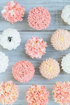 cupcakes decorated with pink and white flowers on a wooden table, top view