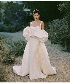 a woman in a white dress standing outside