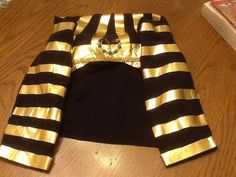 a black and gold outfit sitting on top of a wooden table