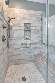 a walk in shower sitting next to a tiled wall