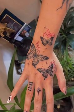 a woman's hand with three butterflies on it and the word love written in cursive writing