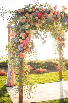 an outdoor ceremony with flowers and greenery