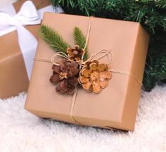 a present wrapped in brown paper and tied with twine, sitting next to a christmas tree