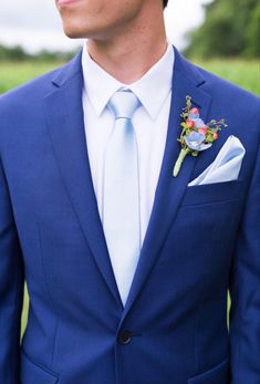 a man in a blue suit with a flower on his lapel