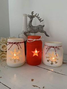 three mason jars with christmas decorations on them