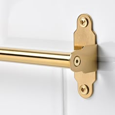 a close up of a door handle on the side of a white door with gold hardware