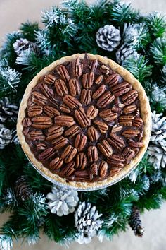 an overhead view of a pecan pie surrounded by pine cones