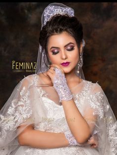 a woman in a white wedding dress and veil with her hands on her face, posing for the camera