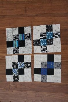 four pieces of black and white quilts laid out on a wooden floor