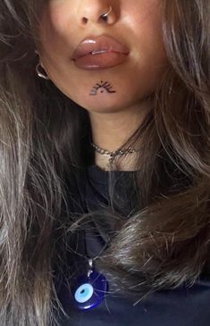 a close up of a person with long hair and piercings on her nose, wearing a black shirt