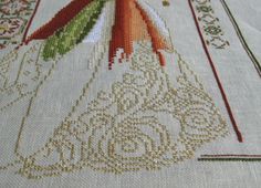 a close up of a cross stitch pattern on a table cloth