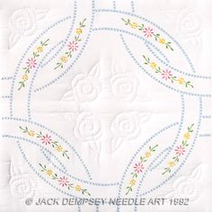 a white table cloth with embroidered designs on it