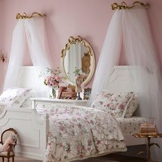 a white bed sitting next to a pink wall