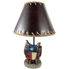 a lamp that has a horse on it with a star in the center and a brown leather shade