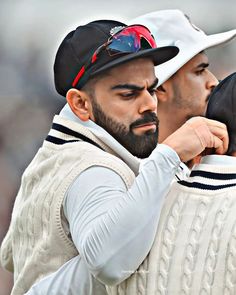 two men in white sweaters and hats standing next to each other