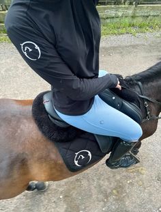 a woman riding on the back of a brown horse