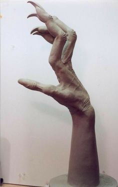 a sculpture of a hand reaching up into the air with it's fingers extended