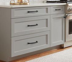 a kitchen with an oven, stove and counter tops in white painted wood paneling