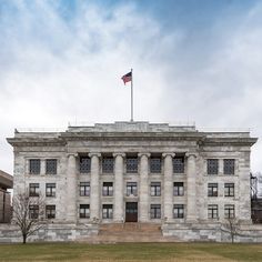 an old building with columns and a flag on top