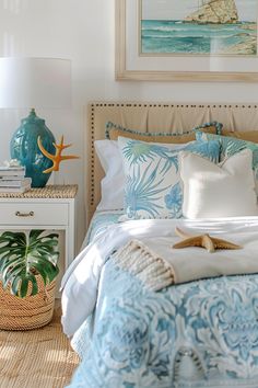 a bed with blue and white comforter in a bedroom next to a painting on the wall