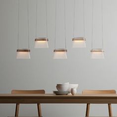 a dining room table with six lights hanging from it