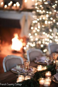 the table is set with candles and place settings for an elegant christmas dinner or celebration