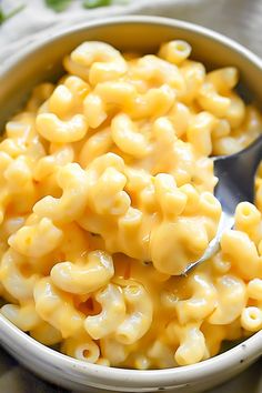 a bowl full of macaroni and cheese with a spoon