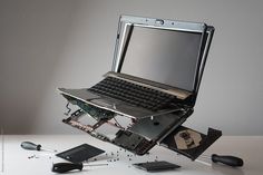 an open laptop computer sitting on top of a table next to other electronic components and tools