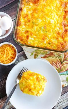 an egg casserole on a white plate next to two bowls of eggs and a fork