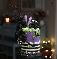 a purple and black cake with flowers on it