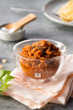 a glass bowl filled with food sitting on top of a table next to other dishes