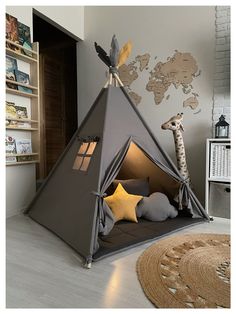 a child's teepee tent with a stuffed giraffe in the corner