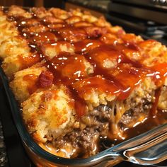 a casserole dish with meat and cheese covered in gravy on top