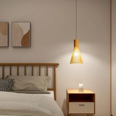 a bedroom with a bed, night stand and two pictures on the wall above it