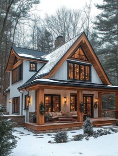 a house in the snow with lots of windows and lights on it's roof