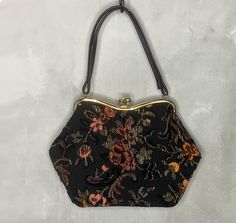 A floral tapestry or carpet handbag from the 50's. It has a gold tone frame, kiss clasp, and vinyl straps, bottom and lining. The shell is yellow, red and pink floral pattern on black. It measures 11" by 8", the strap drop is 6 1/2" and the depth is 3 1/2". Very good condition (some scratches on the top of the metal frame and small scratches on the straps - seen in last two photos). Catalog # 8860 Black Tapestry, Tapestry Handbags, Tapestry Bag, Handbag Vintage, Carpet Bag, Pink Floral Pattern, Vintage Tapestry, Floral Tapestry, Vintage Carpet