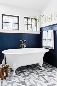 a white bath tub sitting in a bathroom next to a window