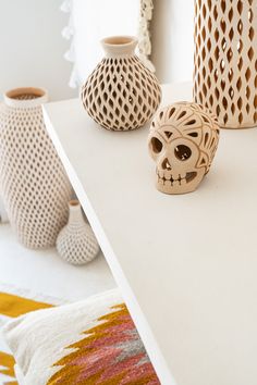 three decorative vases sitting on top of a white table