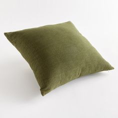 a green pillow sitting on top of a white table