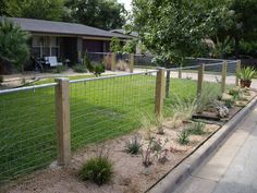 a fenced in yard next to a house with trees and bushes on the side