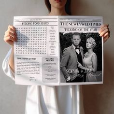 a woman holding up a newspaper with an image of a man and woman on it