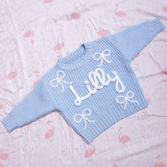 Choosing a personalized hand-embroidered baby sweater is to choose a unique warmth and care for the baby. Let's use this special gift to accompany the baby through every warm moment and witness every step of their growth. Our meticulous craftsmanship is proved on every sweater. These high-quality, super-soft 100% cotton oversized sweaters are hand-made and hand-embroidered (carefully designed and made by us). Colors: black, red, white, blue, dark blue, milky white, apricot, purple, pink, green, Cute Pink Sweater With Custom Embroidery, Big Sis Embroidered Sweater, Baby Name Embroidery Sweater, Embrodered Newborn Crewneck Sweater, Newborn Embroidered Sweater, Baby Name Sweater, Embroidery Bow, Baby Girl Sweater, Name Sweater