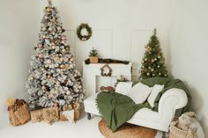 a living room decorated for christmas with white furniture and decorations on the walls, including a small tree