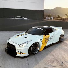 a white sports car parked in front of a building