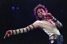 michael jackson performing on stage with his arm extended and holding a microphone in one hand