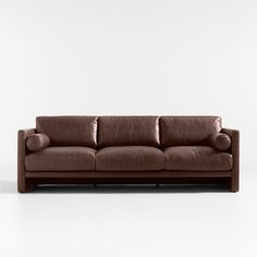 a brown leather couch sitting on top of a white floor