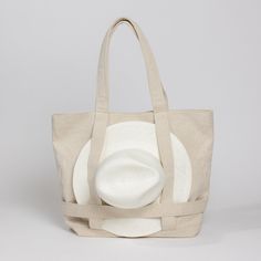 a bag with a white hat on the front and back side, sitting against a gray background